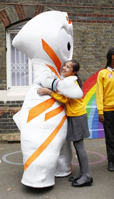 The 2012 Olympic mascot Wenlock hugs a student