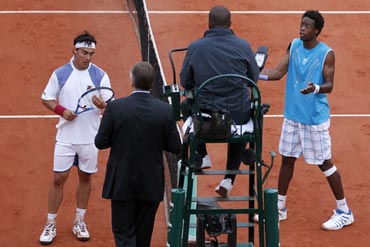 Gael Monfils and Fabio Fognini speak to officials during their match