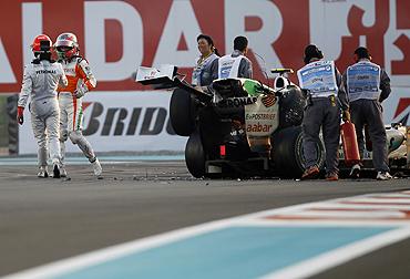 Mercedes's Michael Schumacher walks away from his car after crashing with Force India's Tonio Liuzzi during the Abu Dhabi F1 Grand Prix at Yas Marina circuit on Sunday