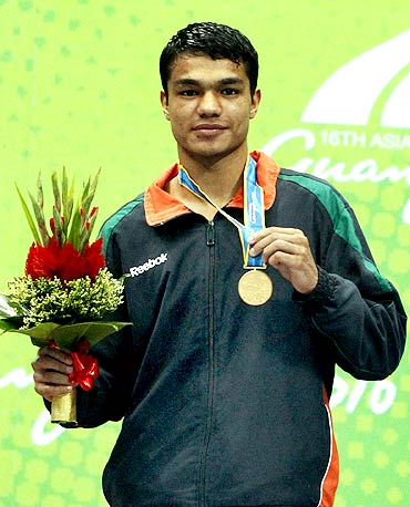 Krishan Vikas of India holds his gold medal after winning the men's 60kg boxing event at the 16th Asian Games in Guangzhou