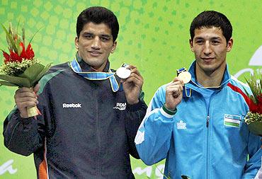 Elshod Rasulov (R) of Uzbekistan stands with Dinesh Kumar of India after their men's 81kg gold medal boxing match at the 16th Asian Games in Guangzhou