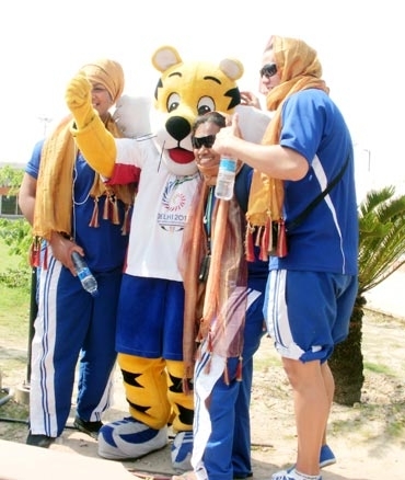Athletes from Tuvalu pose with Sheru the mascot