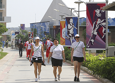 Members from New Zealand's team walk inside the Games Village