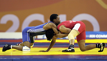India's Babita Kumari (red) challenges Nigeria's Christi Nwoye during their 51kg women's freestyle wrestling match on Friday