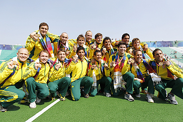 Australia's players pose with their gold medals after beating India in their men's field hockey final