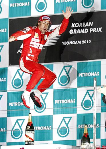 Ferrari Formula One driver Fernando Alonso of Spain jumps as he celebrates on the podium after winning the South Korean F1 Grand Prix