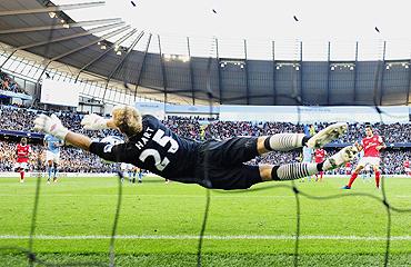 Manchester City's Joe Hart (left) saves a penalty from Arsenal's Cesc Fabregas (right) on Sunday