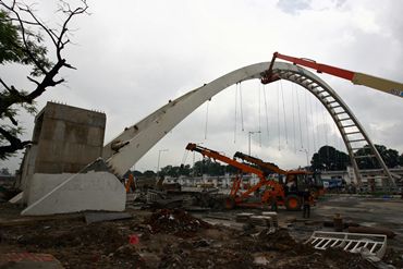A crane removes the rubble of the collapsed bridge at the J N Stadium