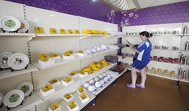 A member of the Scottish team browses through artifacts inside a handicraft shop at the Games Village