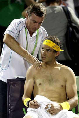 Nadal receives treatment from ATP trainer Paul Ness between games against Tomas Berdych