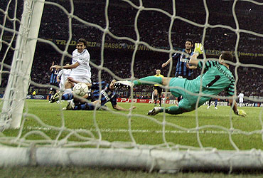 Schalke 04's Raul Gonzalez (left) scores past Inter Milan's goalkeeper Julio Cesar (right) and Andrea Ranocchia (2nd from left)
