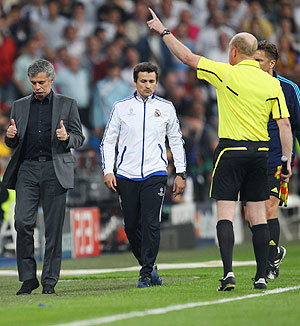 Real Madrid's coach Jose Mourinho (left) gives a thumbs up to the assistant referee after being sent off to the stands