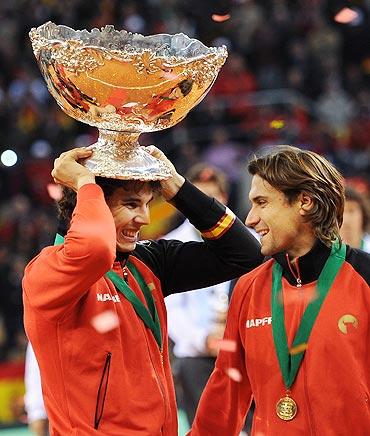 Rafael Nadal (left) of Spain holds the Davis Cup trophy as he celebrates with his team-mate David Ferrer