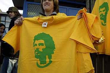 Fans hold tee shirts depicting Brazilian football legend Socrates