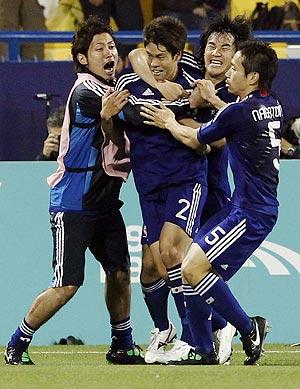 Japan's Masahiko Inoha (centre) celebrates with teammates after scoring the winning goal against Qatar on Friday