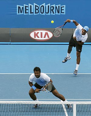 Mahesh Bhupathi serves as Leander Paes of India watches during their match against Juan Monaco of Argentina and Feliciano Lopez of Spain on Saturday