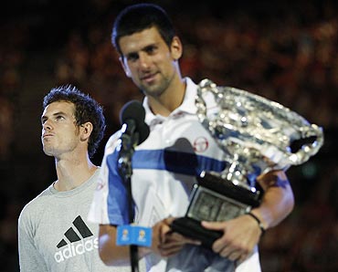 Andy Murray looks away as Novak Djokovic of Serbia holds his trophy