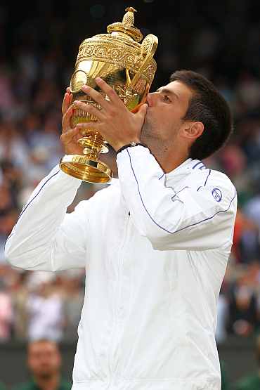 Novak Djokovic kisses the trophy after winning his final against Rafael Nadal