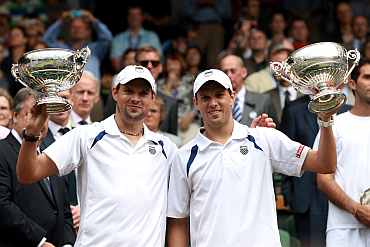 Bob Bryan (L) and Mike Bryan hold up their Championship trophies after winning their final round Doubles match against Horia Tecau and Robert Lindstedt