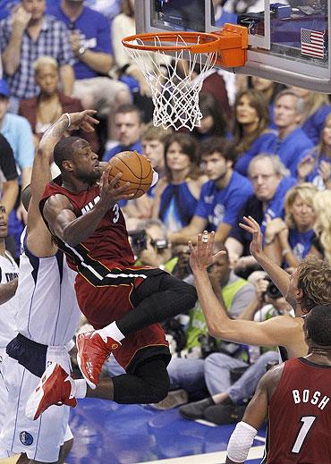 Miami Heat's Dwyane Wade (centre) goes up for a basket against the Dallas Mavericks