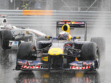 Red Bull's Sebastian Vettel drives followed by Sauber's Kamui Kobayashi