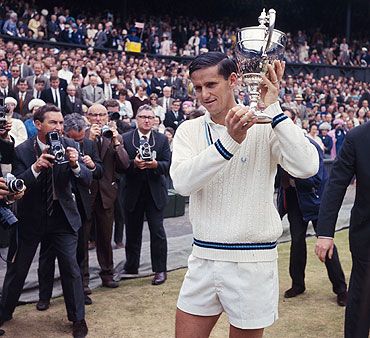 Australian tennis player Roy Emerson raises the men's singles trophy after beating fellow-Australian Fred Stolle in the 1965 Wimbledon final