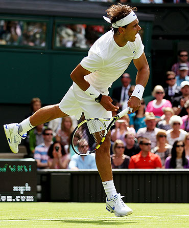 Rafael Nadal serves during his first round match against Michael Russell