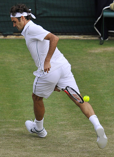 Roger Federer hits a return between the legs during his match against Mikhail Youzhny