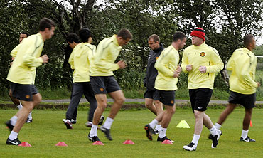 Manchester United's players warm up during a practice session at the club's Carrington training ground in Manchester