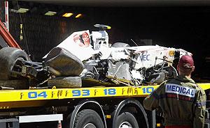 A medic looks at the mangled remains of the car of Sauber Formula One driver Sergio Perez after he crashed during the qualifying session of the Monaco F1 Grand Prix on Saturday