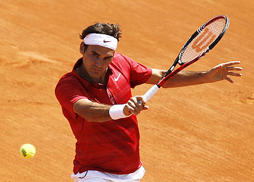 Switzerland's Roger Federer returns the ball to compatriot Stanislas Wawrinka