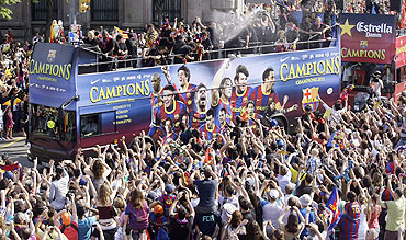Barcelona's players celebrate on top of a bus with their supporters after winning their Champions League final against Manchester United on the streets of Barcelona on Sunday
