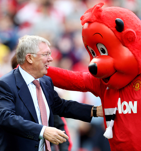 Manchester United Manager Sir Alex Ferguson is greeted by mascot Fred the Red