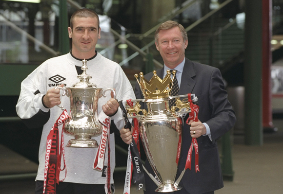 Eric Cantona (left) of Manchester United and Alex Ferguson (right) Manager of Manchester United hold the trophies after winning the F A Cup and the Premier League