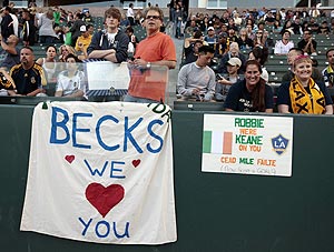 Fans put up a placard of David Beckham before a football match at San Jose