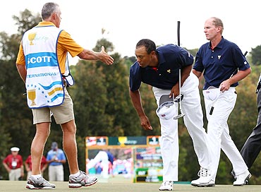 Tiger Woods looks on as Steve Williams, caddie to Adam Scott (not pictured), shake hands with Steve Stricker