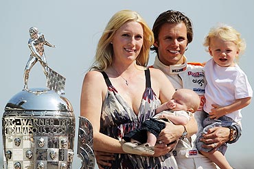 Dan Wheldon of England, holds son Sebastian alongside wife Susie holding Oliver, with the Borg Warner Trophy