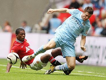 Patrice Evra of Manchester United tackles James Milner of Manchester City