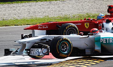 Fernando Alonso of Ferrari and Michael Schumacher (bottom) of Mercedes GP fight for position
