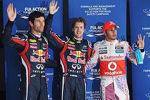 Pole sitter Sebastian Vettel (centre) of Red Bull celebrates with second placed Mark Webber (L) of Red Bull Racing and third placed Lewis Hamilton (R) of McLaren after qualifying for the Indian Formula One Grand Prix at the Buddh International Circuit on Saturday