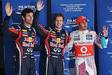 Red Bull's Pole sitter Sebastian Vettel (centre) celebrates with teammate and second placed Mark Webber (left) and third placed Lewis Hamilton (right) of McLaren after qualifying