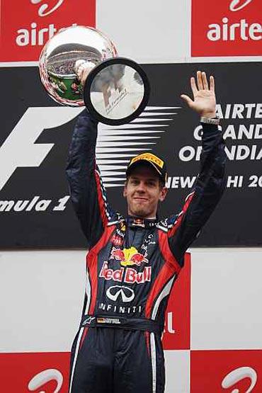 Sebastian Vettel of Germany and Red Bull Racing celebrates on the podium after winning the Indian Formula One Grand Prix