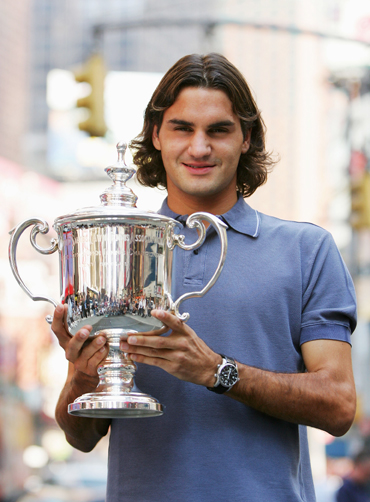 oger Federer of Switzerland poses for a picture with his 2004 US Open trophy in Time Square on September 13, 2004 in New York City