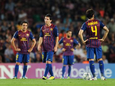 Lionel Messi (2nd L) of FC Barcelona stands dejected with his teammates after conceding a goal during the UEFA Champions League group H match