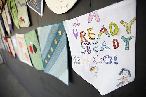 A banner is seen along with others made by scout and brownie groups to decorate an observation point opposite the Olympic Park in East London