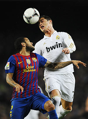 Dani Alves of FC Barcelona (left) duels for a high ball with Cristiano Ronaldo of Real Madrid