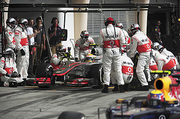 Mechanics work in the car of McLaren Formula One driver Lewis Hamilton of Britain as he pits during the Bahrain F1 GP on Sunday