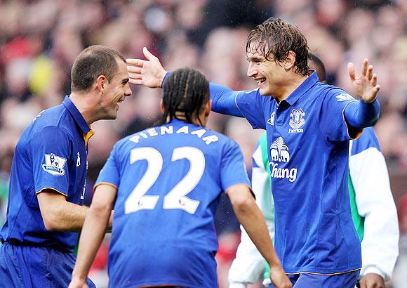 Nikica Jelavic of Everton celebrates scoring the opening goal with team-mates Darron Gibson (left) and Steven Pienaar during the EPL match against Manchester United at Old Trafford on Sunday