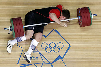 Matthias Steiner of Germany gets hit by the weights while failing to make a successful lift in the men's over 105-kg, group A, weightlifting competition on Tuesday