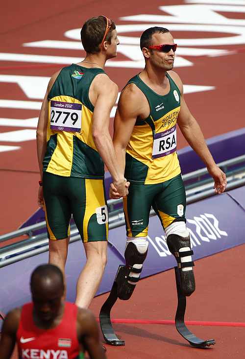 South Africa's Oscar Pistorius and Willem de Beer react after their team did not finish in the men's 4x400m relay round 1 heat